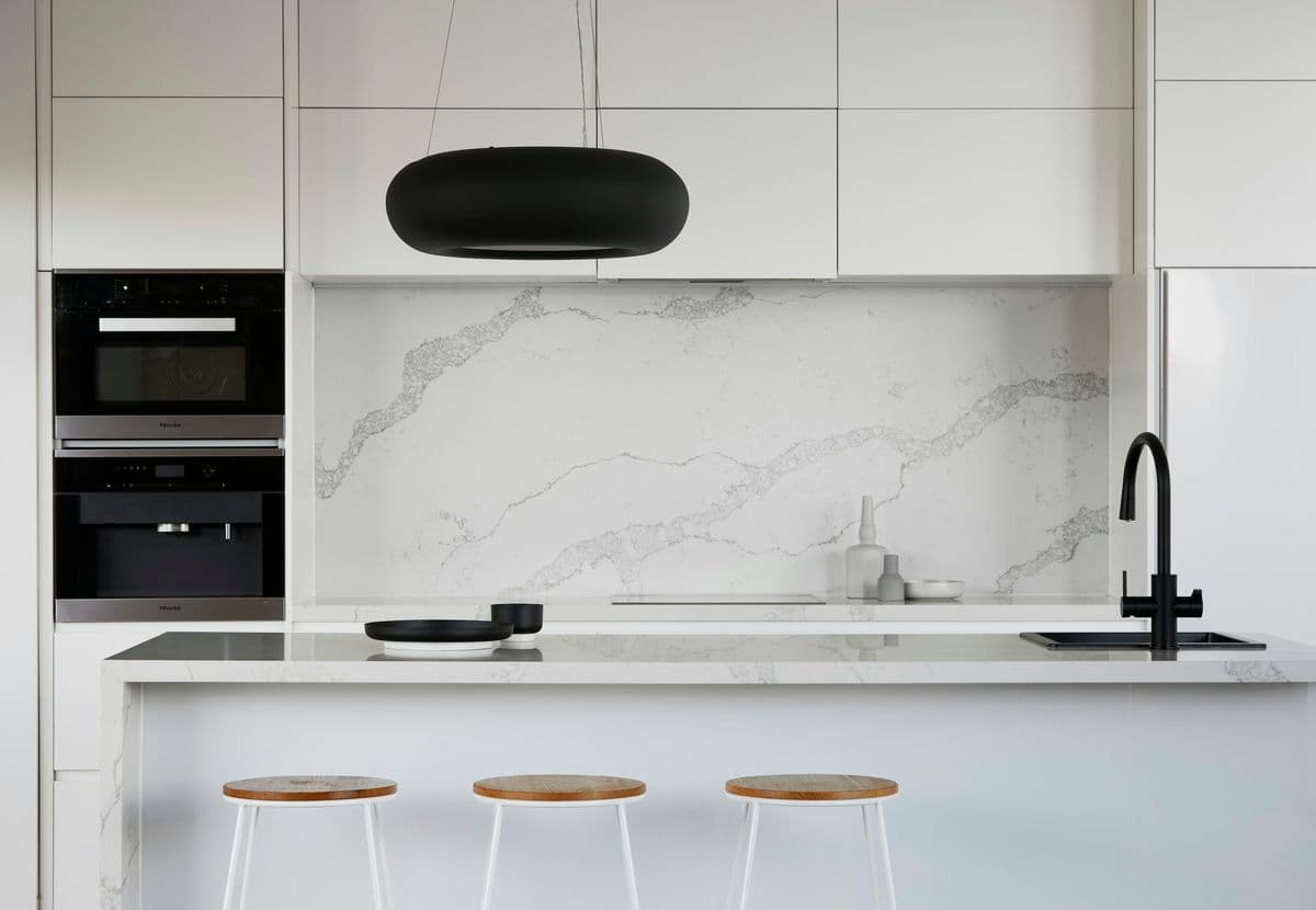 Built-in ovens set into marble-clad joinery