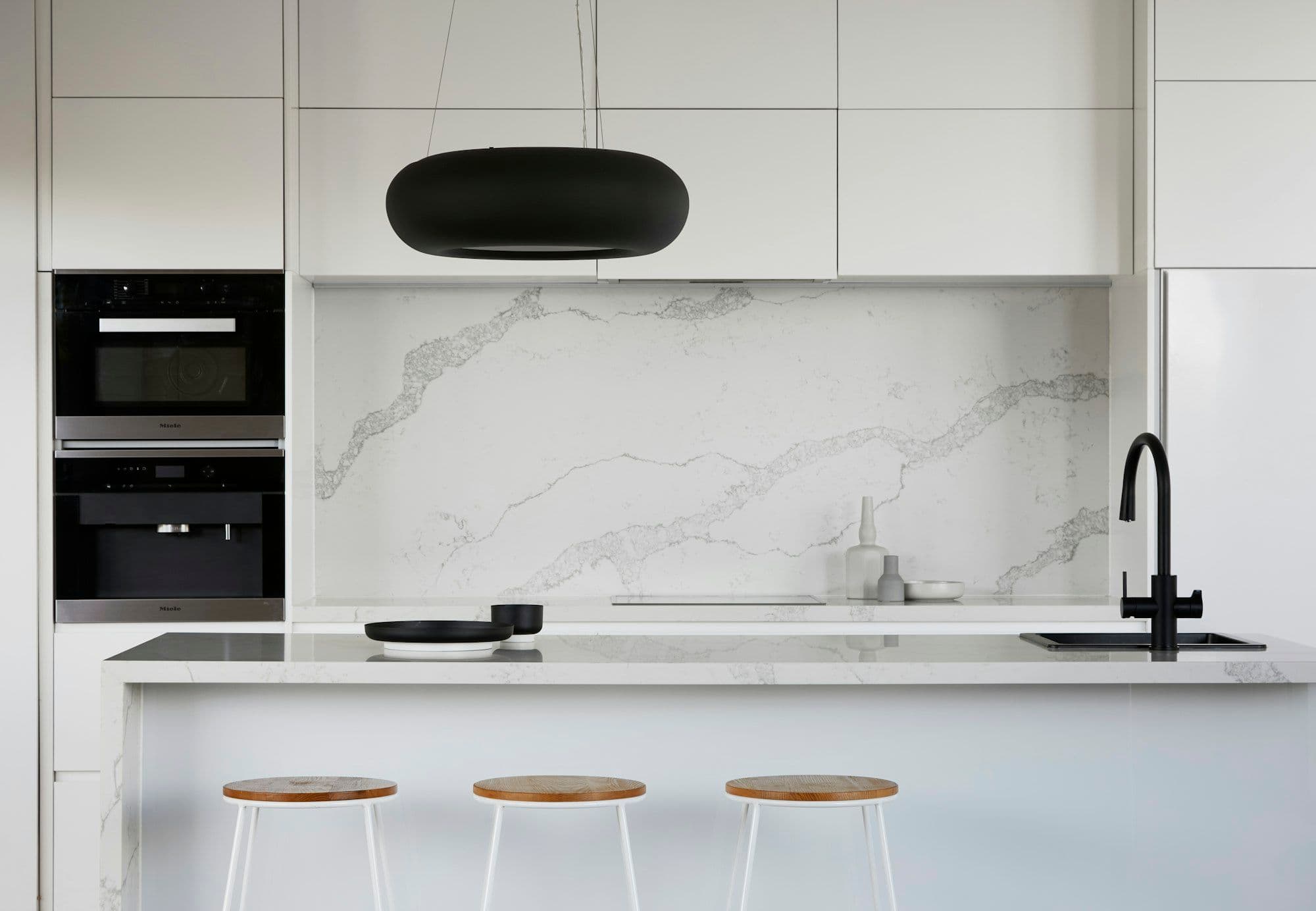 Built-in ovens set into marble-clad joinery