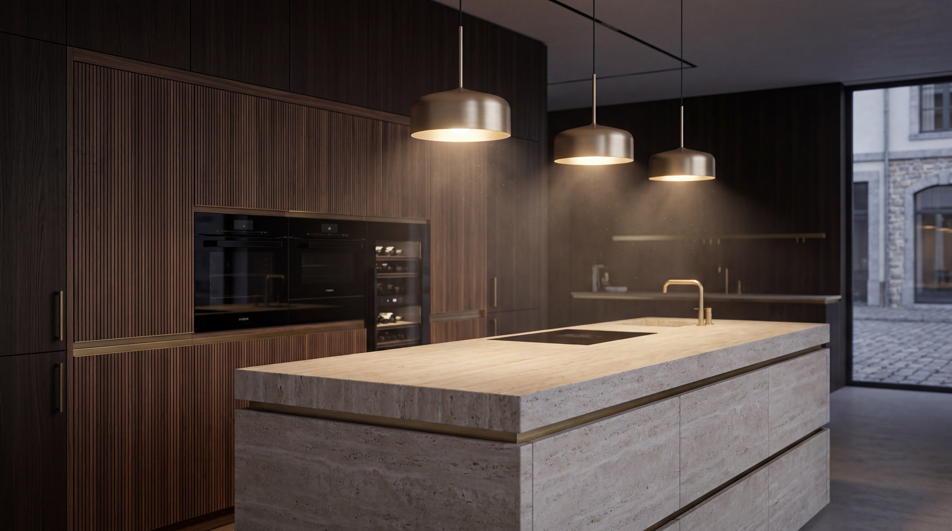 A dark luxury kitchen with integrated ovens under warm pendant lighting