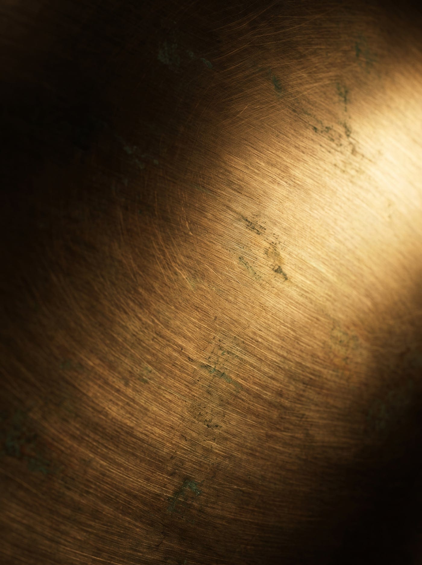 Macro study of a brushed bronze-toned panel with fine directional grain
