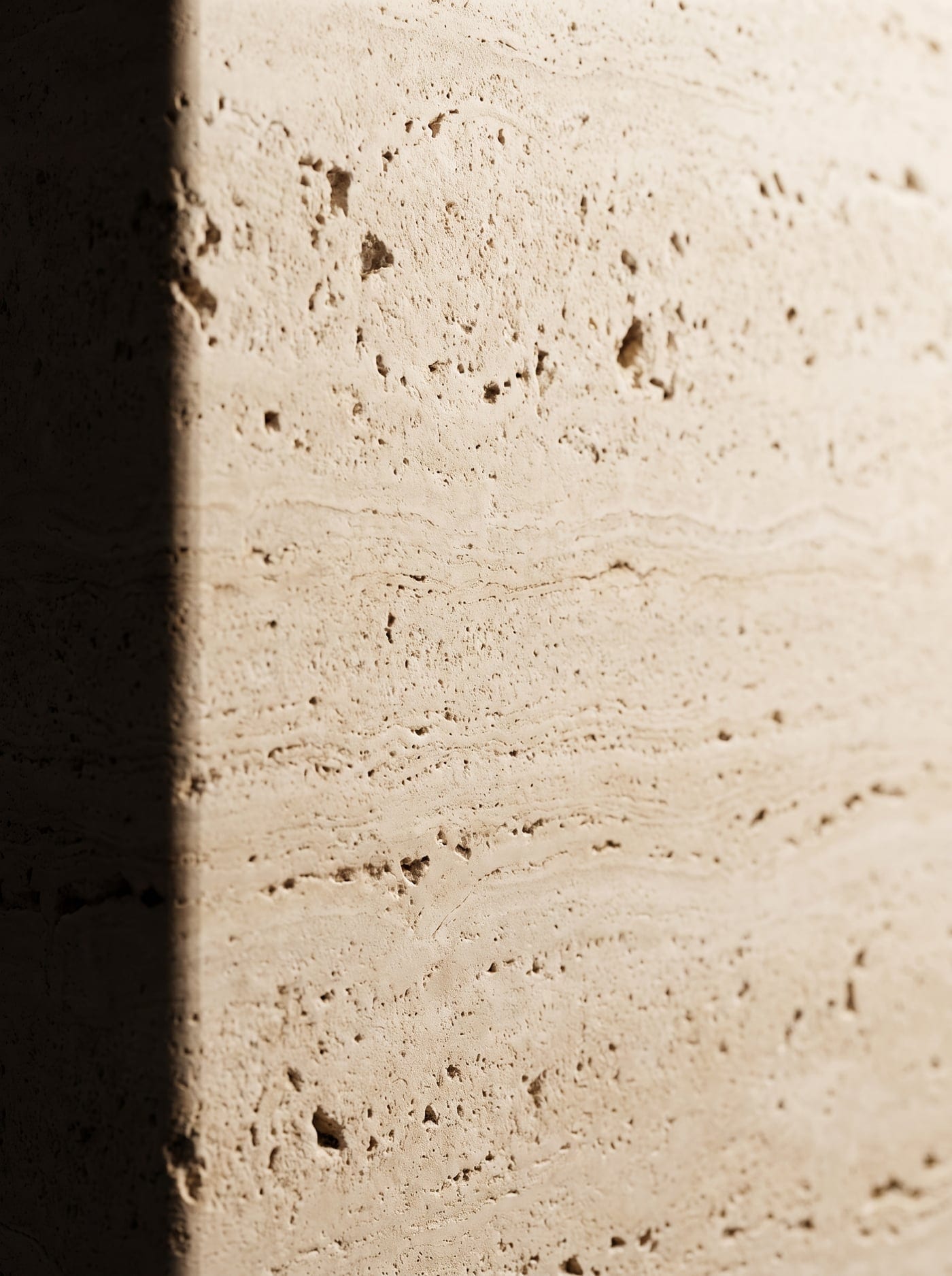Macro study of honed travertine with natural pitting and sediment lines